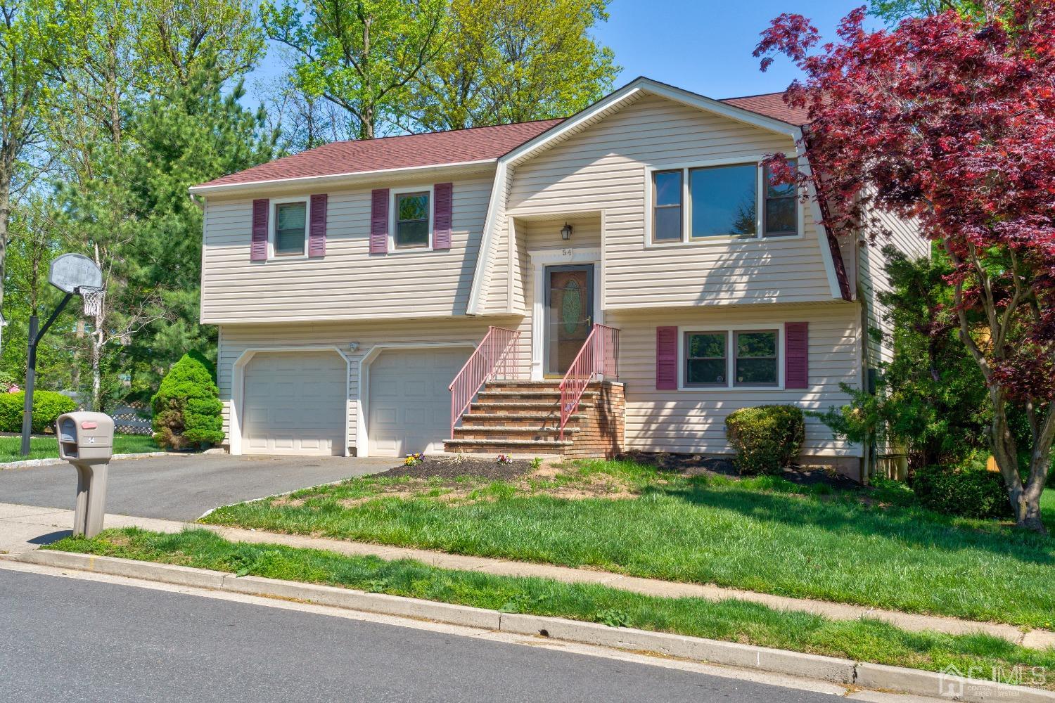 a front view of a house with a garden and yard