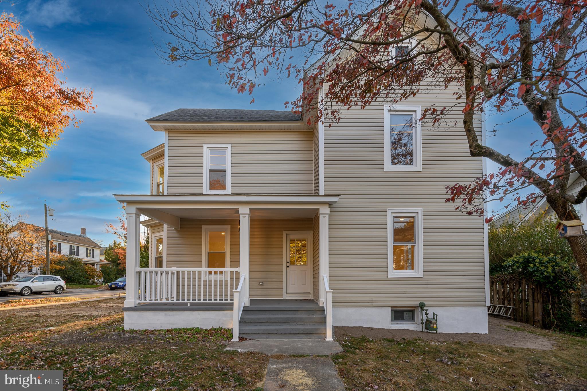 a front view of a house with a tree