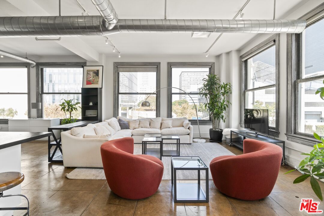 a living room with furniture and floor to ceiling windows