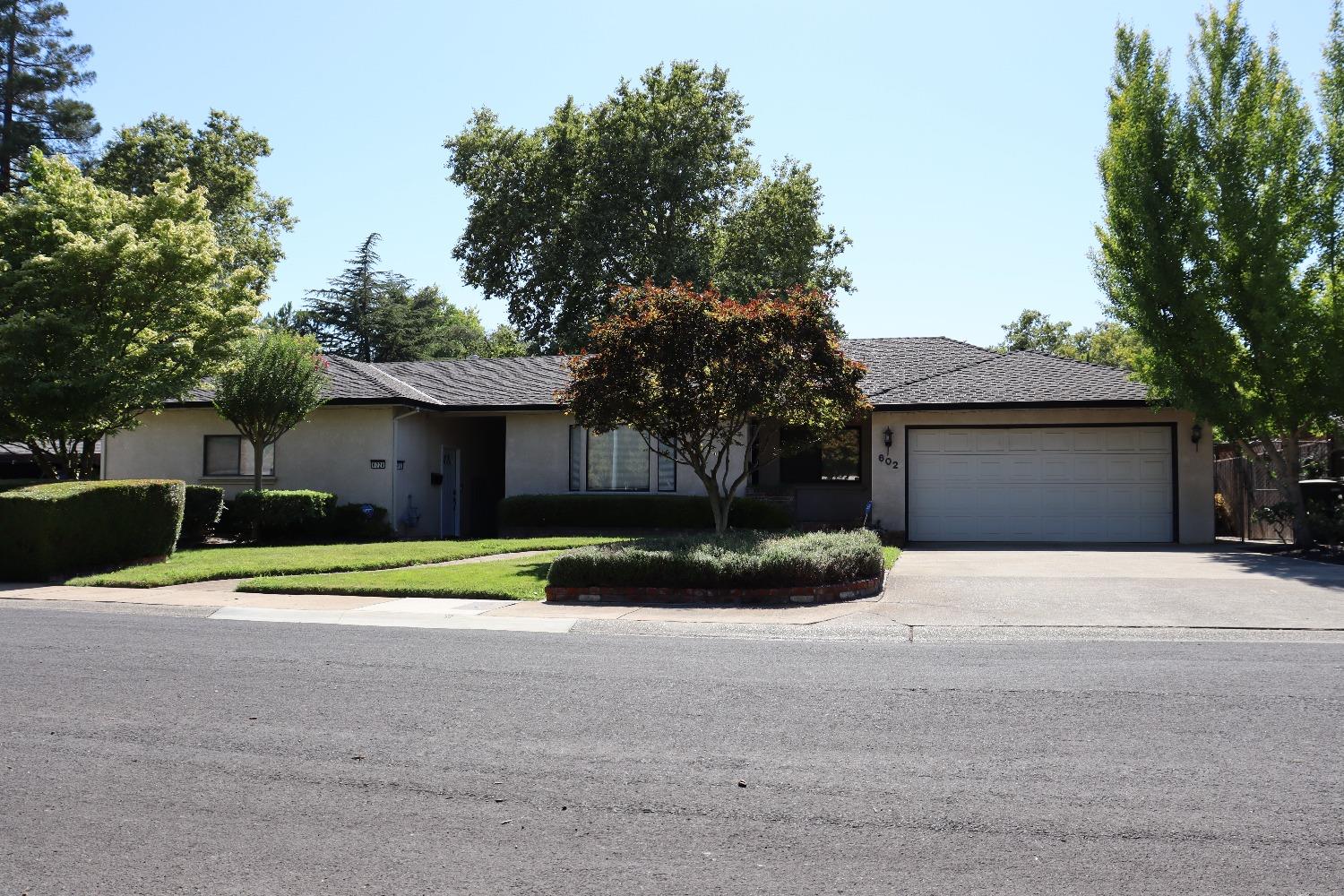 a front view of a house with a yard and a garage