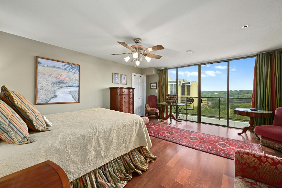 The luxurious primary bedroom features a private terrace with stunning views of Lady Bird Lake, elegant wood flooring, and a ceiling fan for added comfort and ambiance. It also boasts three large closets, including a spacious walk-in closet, providing ample storage space for your convenience.