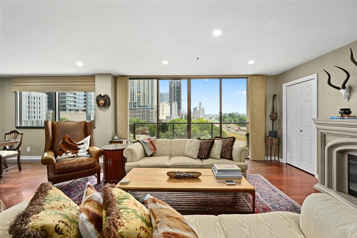 a living room with furniture large windows and a fireplace