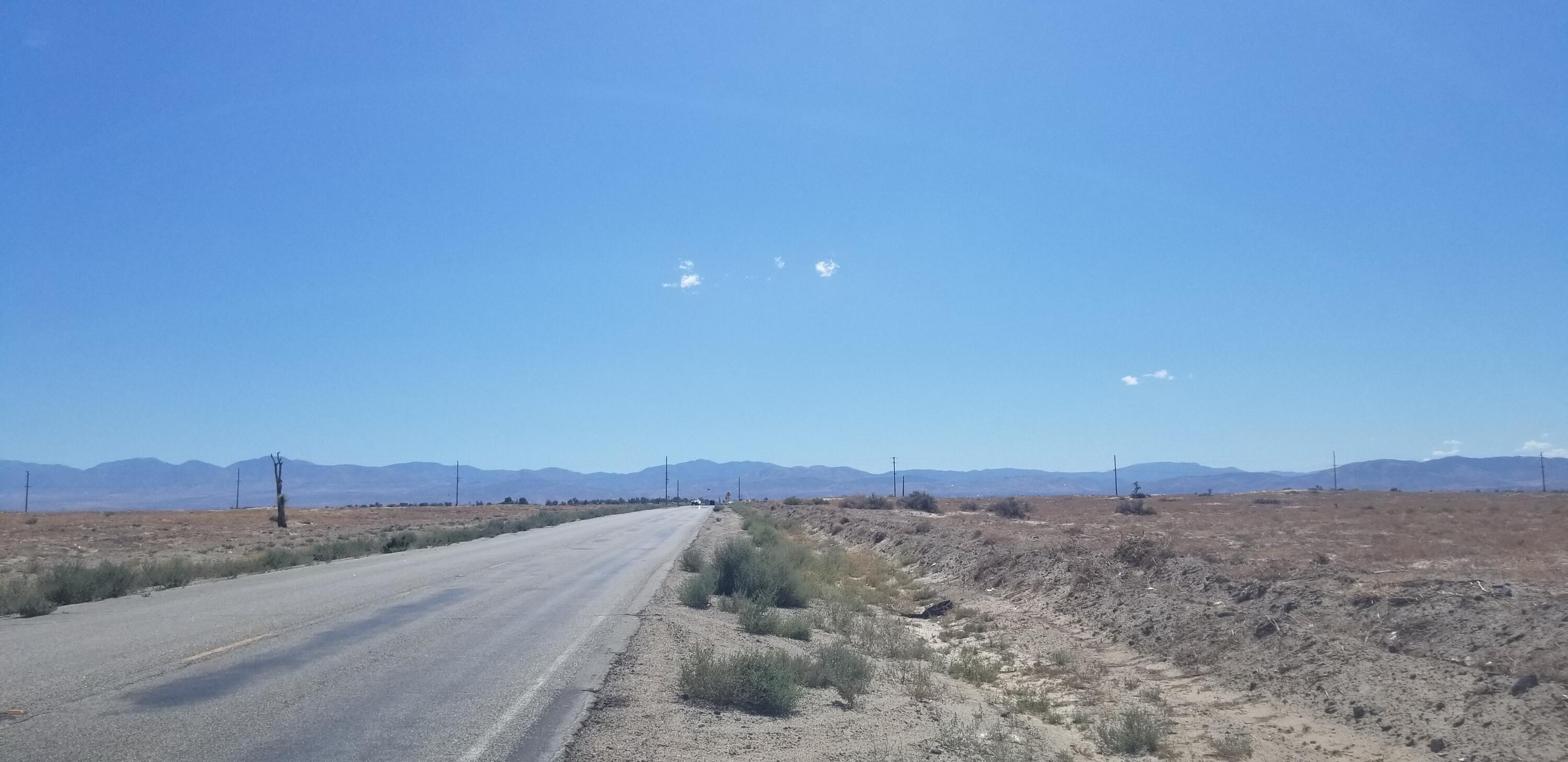 a view of a dry yard with mountain view