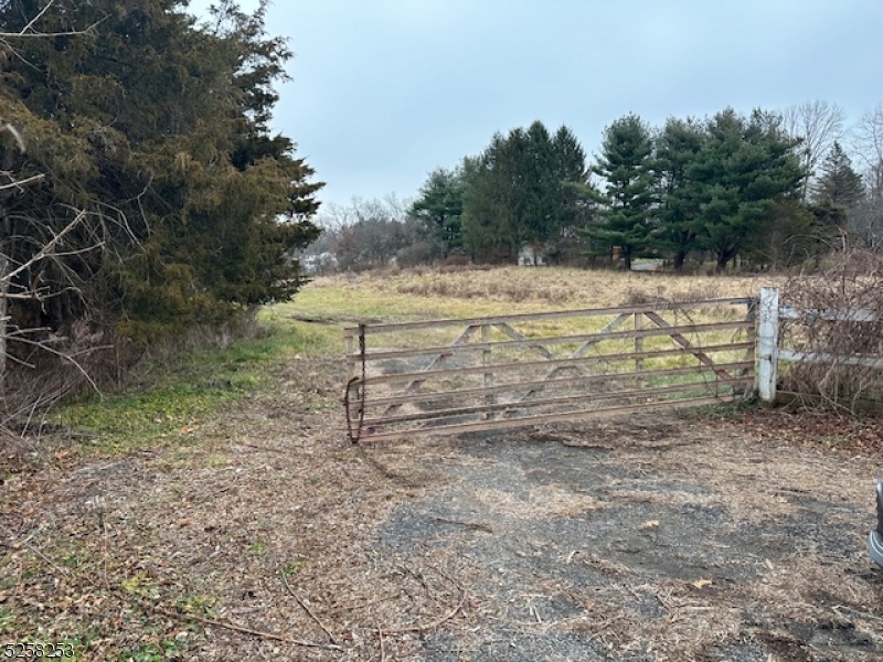 a view of a yard with wooden fence