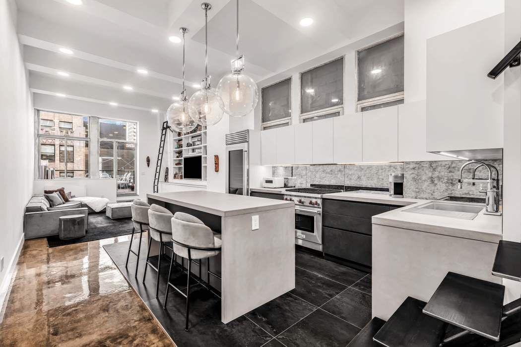 a kitchen that has a lot of white cabinets and stainless steel appliances