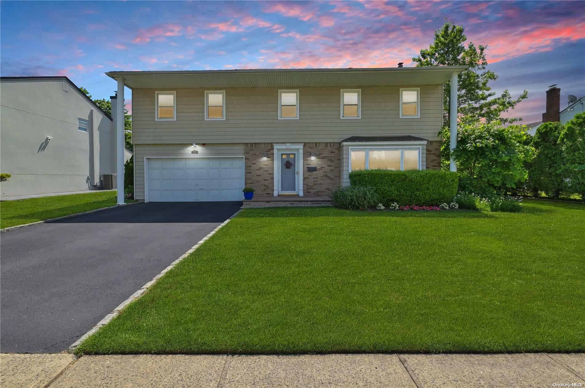 a front view of a house with a yard and garage