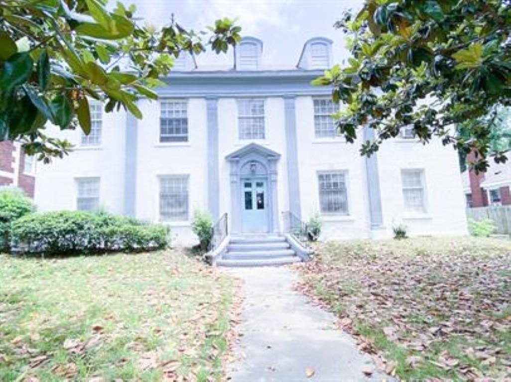 a front view of a house with a garden