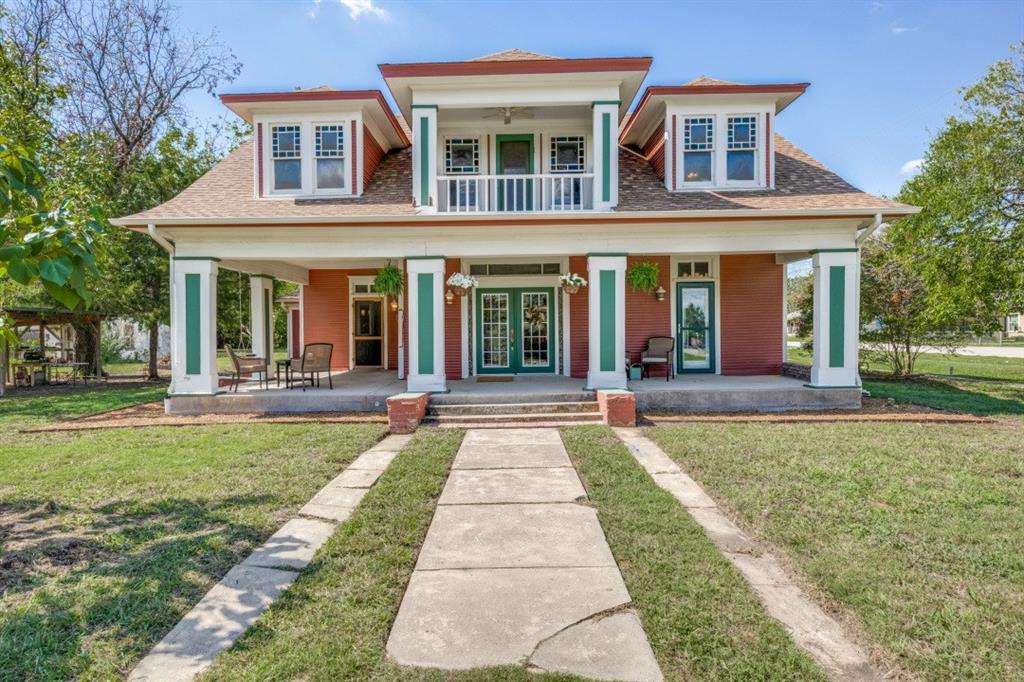 front view of a brick house with a yard