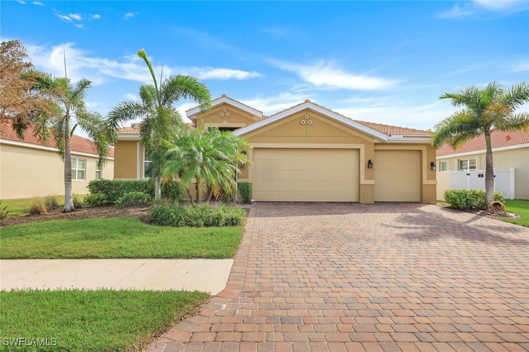 a front view of a house with a garden and palm trees