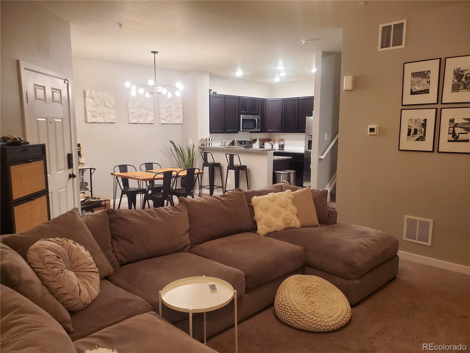 a living room with furniture kitchen and a chandelier