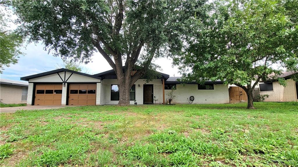 Single story home featuring a garage and a front yard