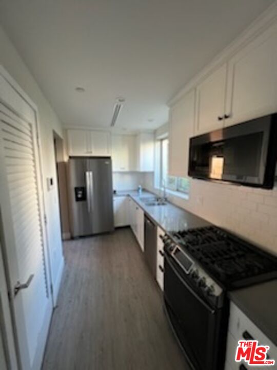 a kitchen with stainless steel appliances kitchen island granite countertop a stove and a refrigerator