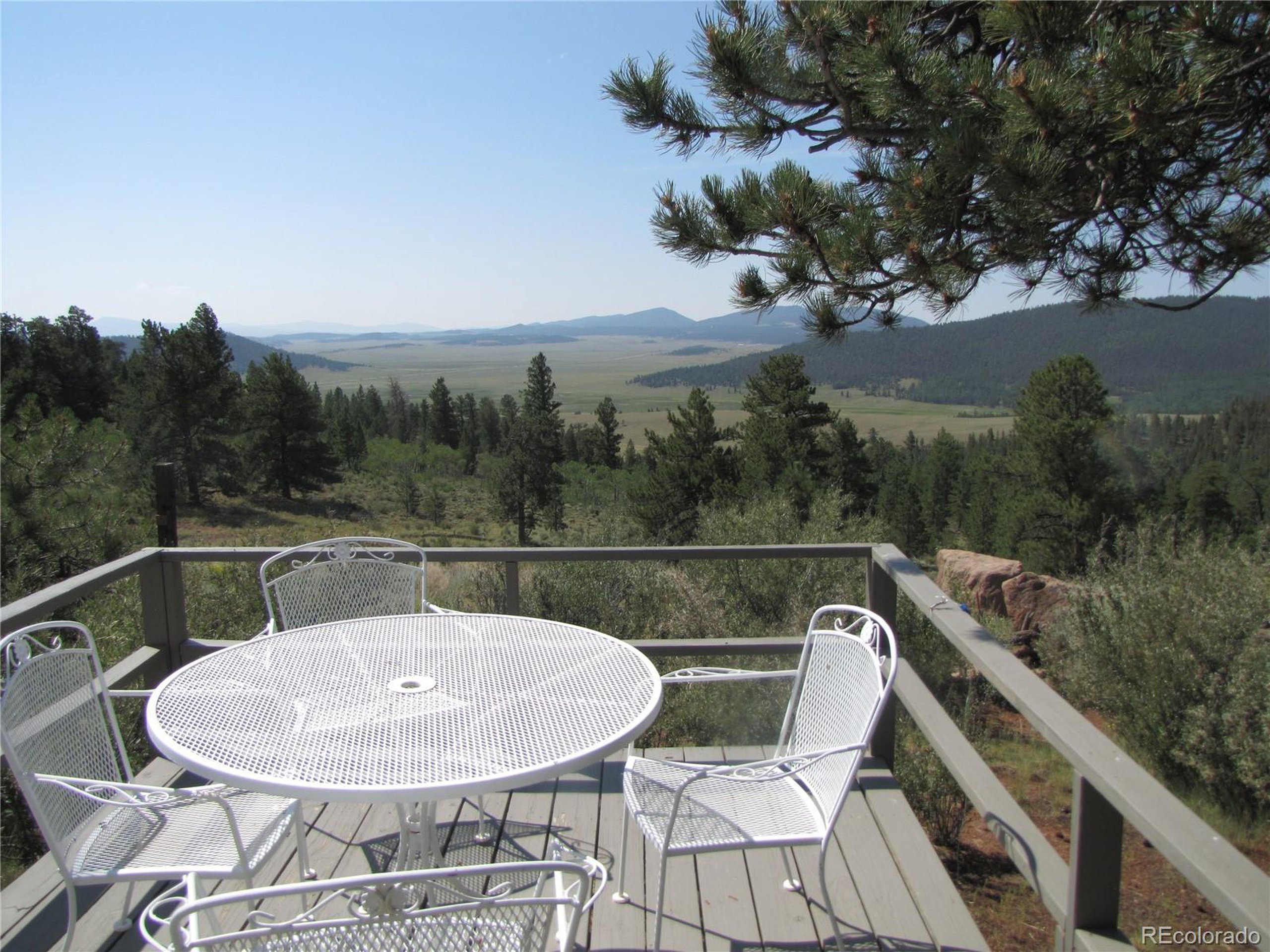 a balcony with table and chairs