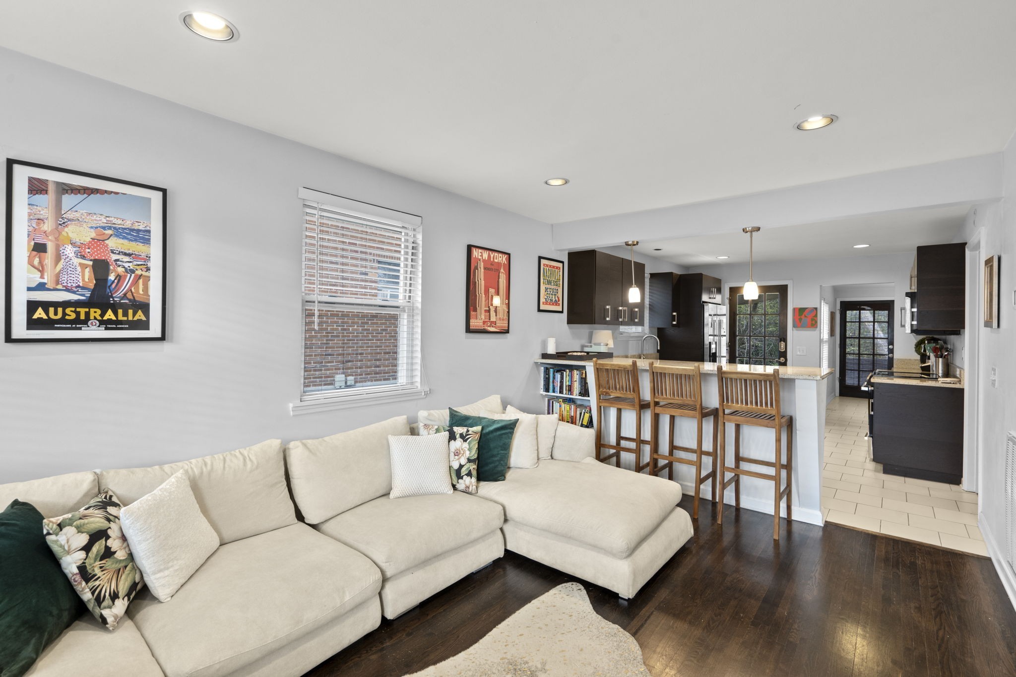 a living room with furniture wooden floor and kitchen view