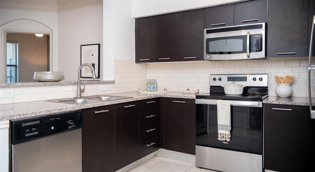 a kitchen with a sink and steel appliances