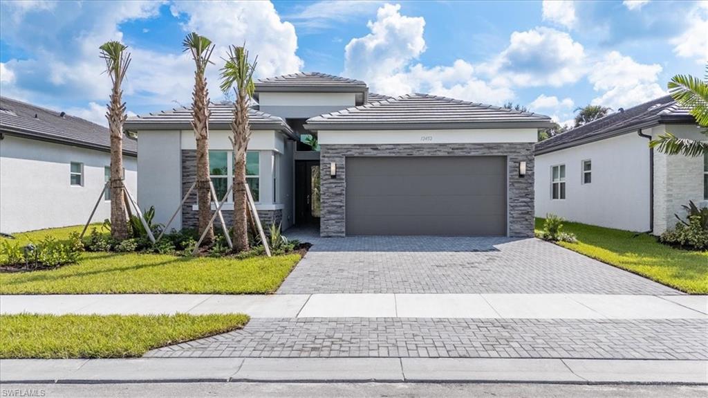 a front view of a house with a yard and garage