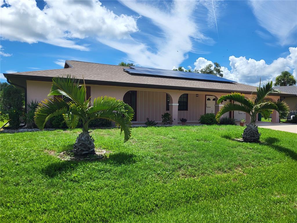 a front view of house with a garden