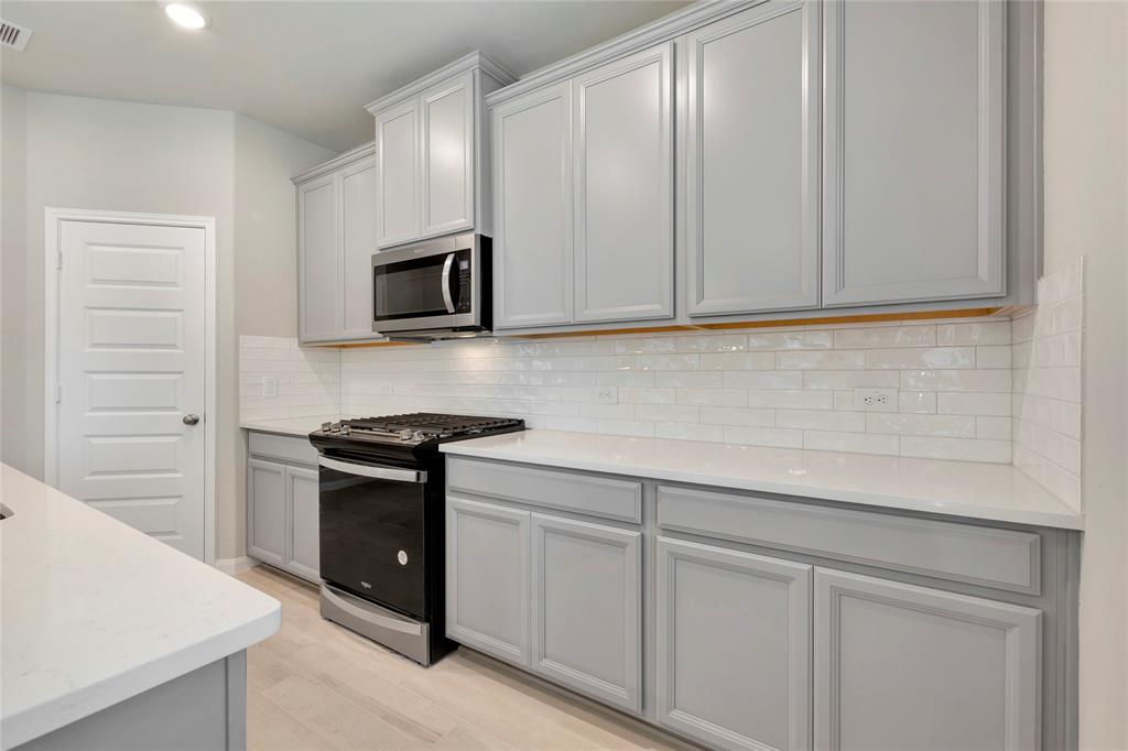 a kitchen with white cabinets and stainless steel appliances