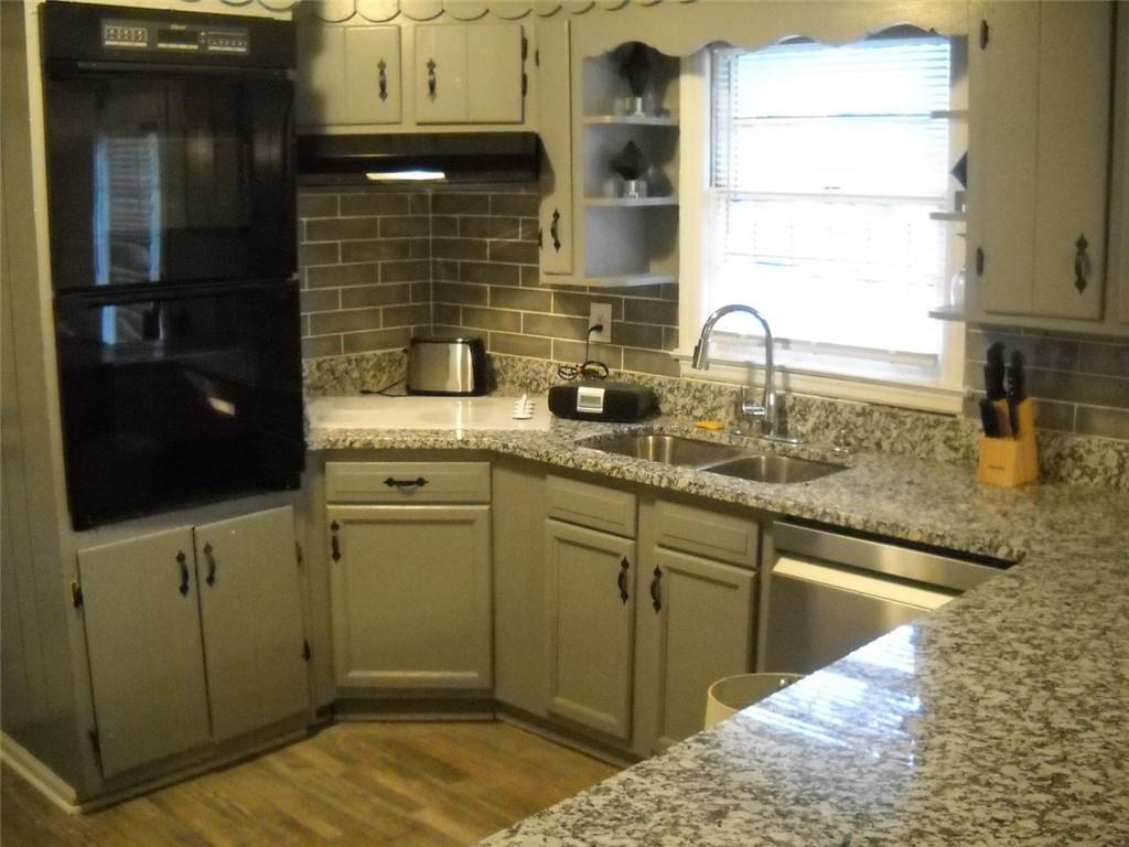 a kitchen with stainless steel appliances granite countertop a sink and cabinets