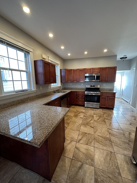 a kitchen with stainless steel appliances granite countertop a sink and a stove