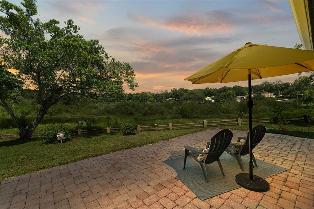 a view of a lake with a table and chairs under an umbrella