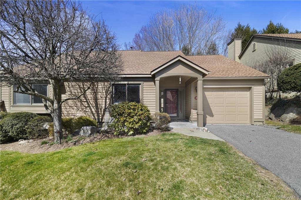 a front view of house with yard and trees around