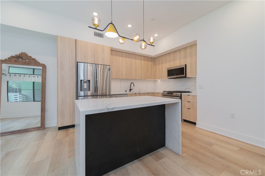 a kitchen with kitchen island a sink stainless steel appliances and cabinets