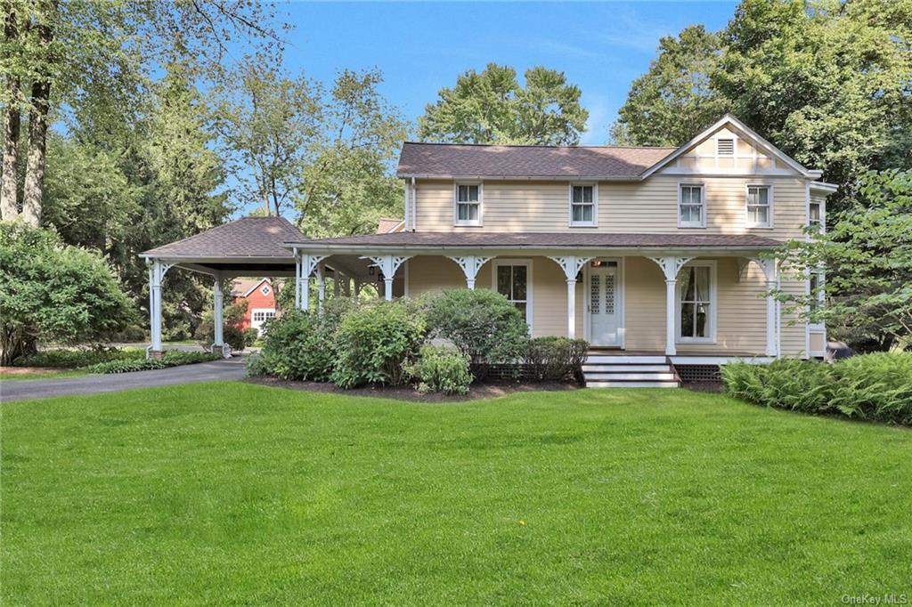 Country-style home featuring covered porch and a front yard