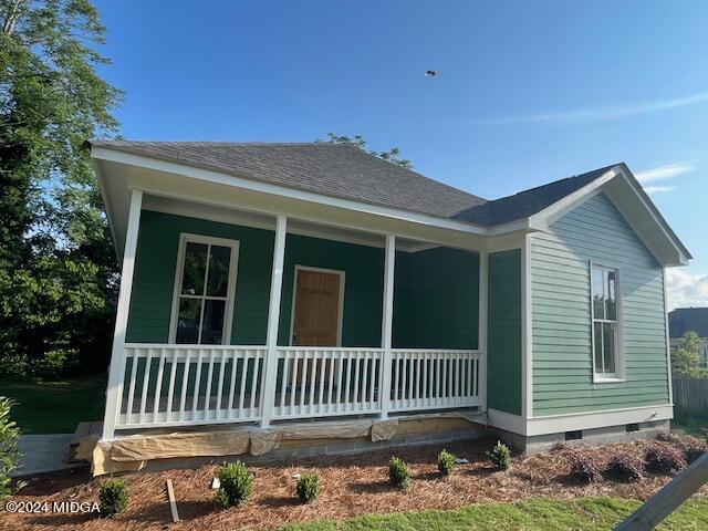 a porch with a bench in front of a house