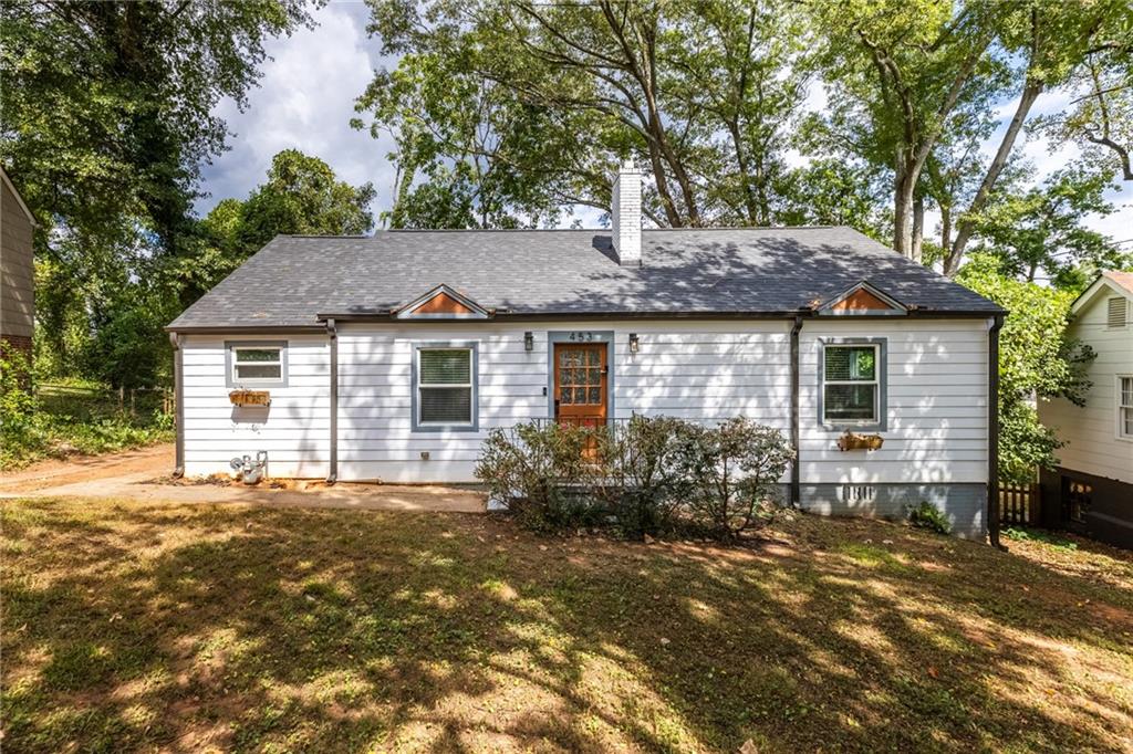 a front view of house with yard and trees around