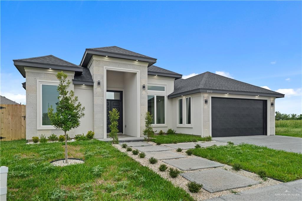 a front view of a house with a yard and garage