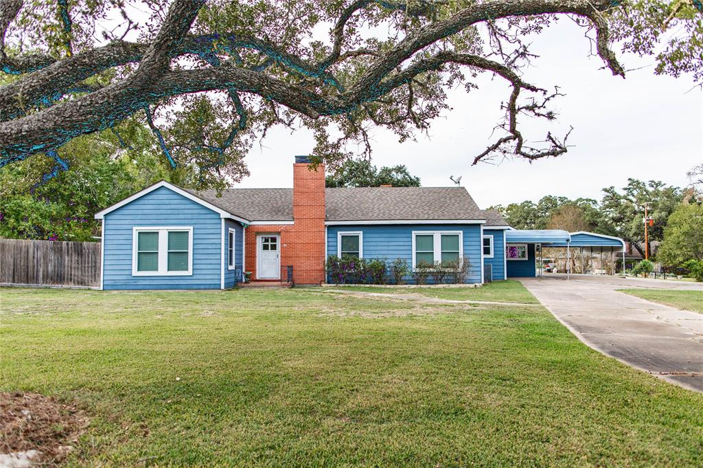 a front view of a house with yard and tree