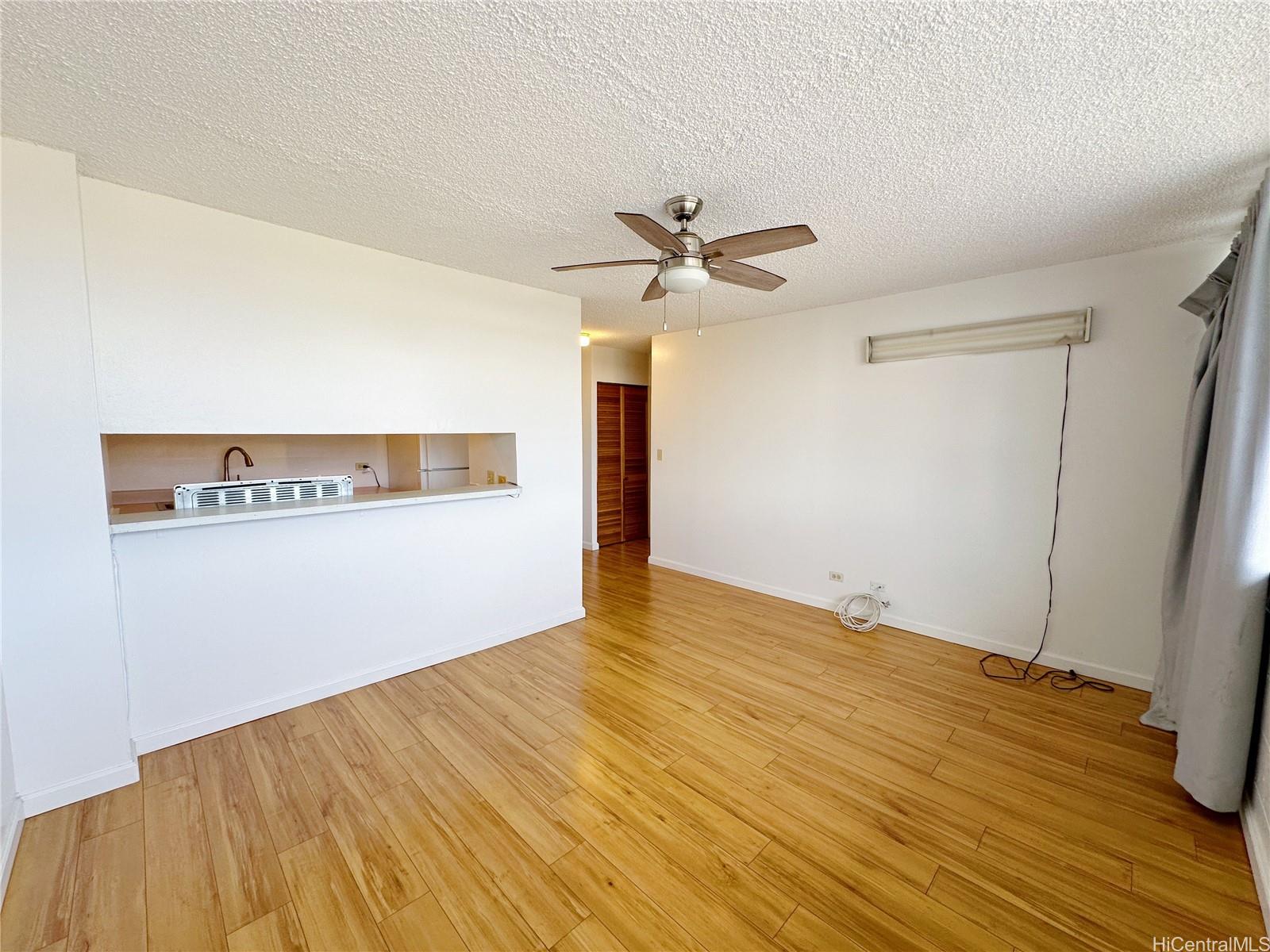 a view of a big room with wooden floor and a ceiling fan