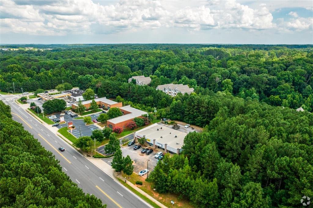 an aerial view of residential houses with outdoor space and trees