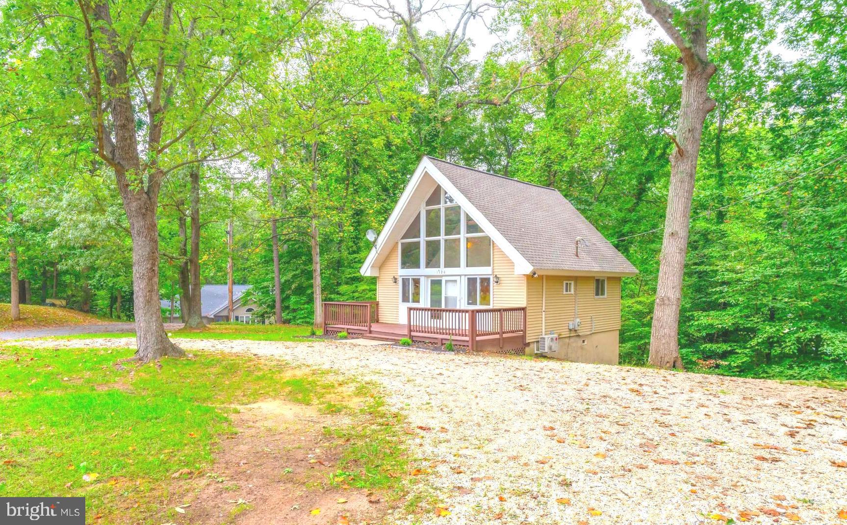 a view of a house with backyard and trees