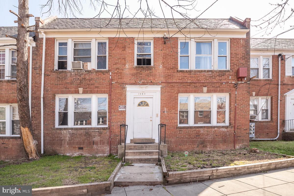 front view of a brick house with a yard