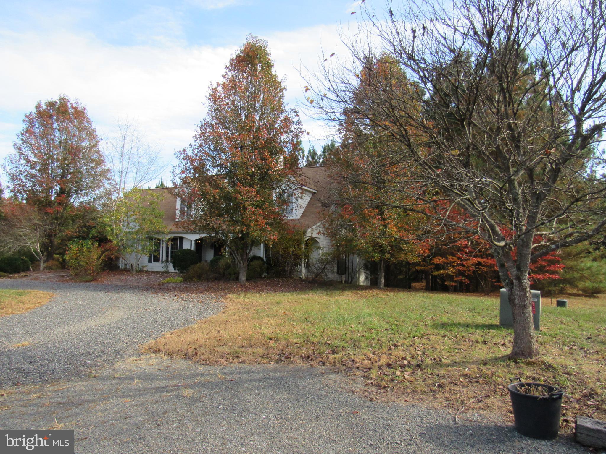 a view of a house with backyard and trees