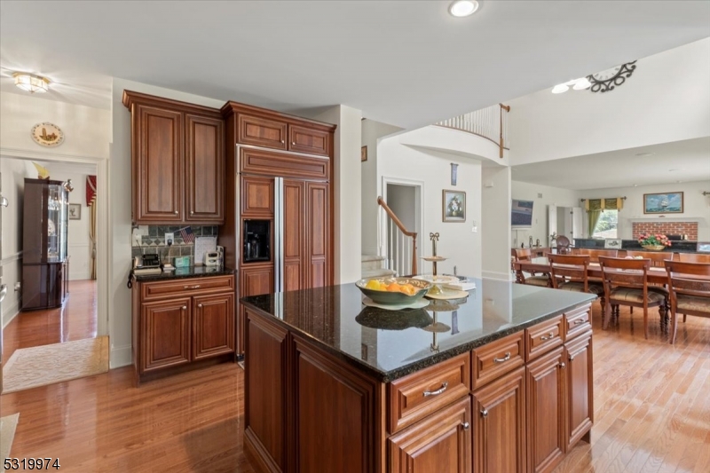 a kitchen with stainless steel appliances granite countertop a refrigerator a stove and a sink with couches