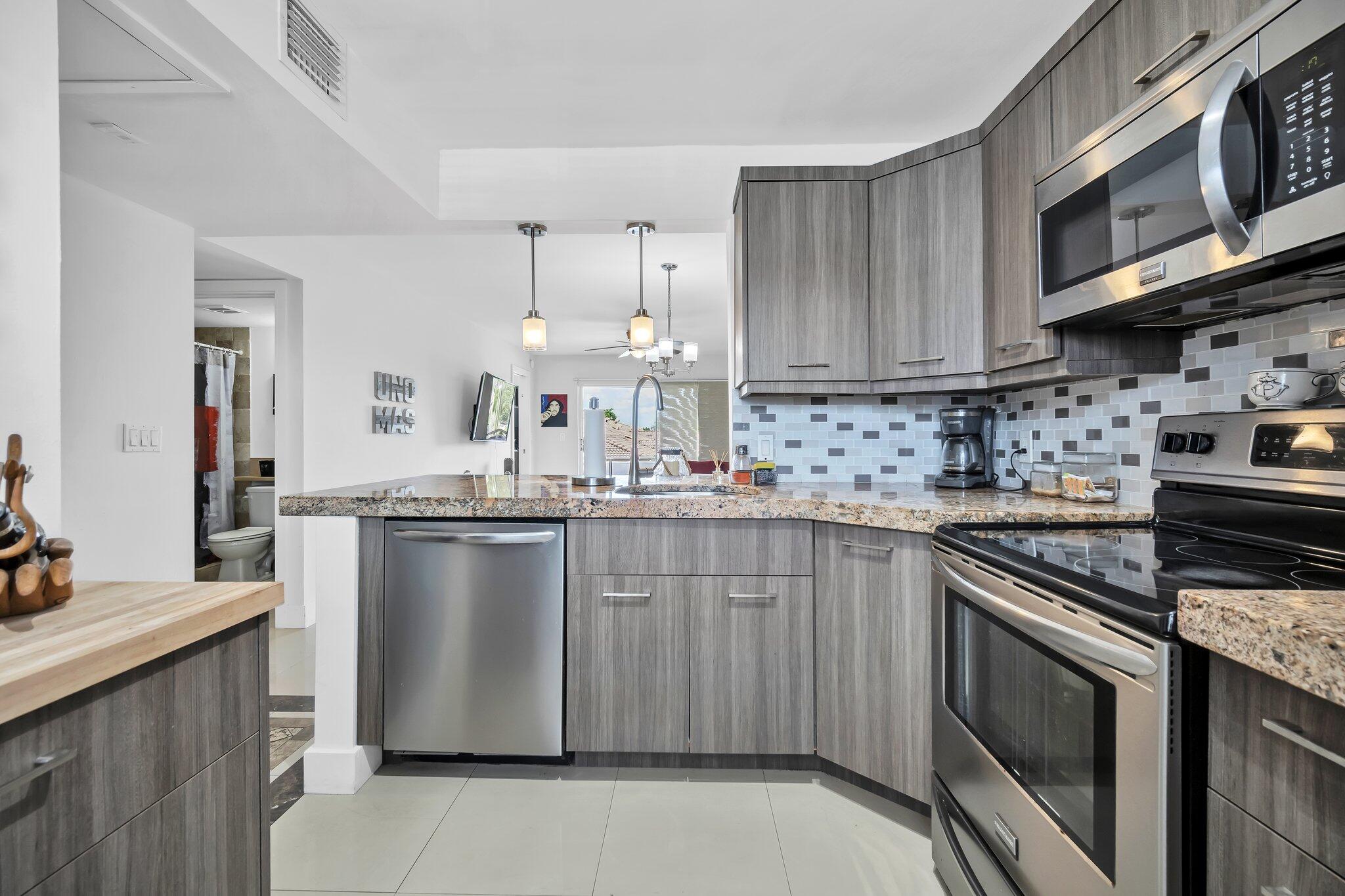 a kitchen with stainless steel appliances granite countertop a sink stove and microwave