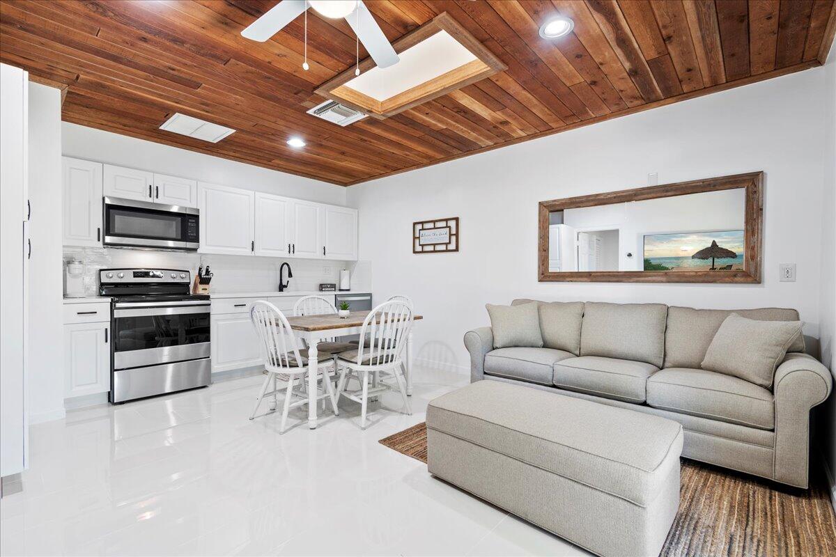 a living room with furniture a flat screen tv and kitchen view