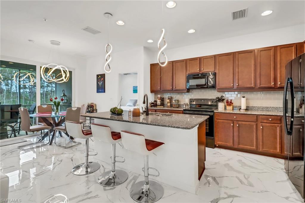 a kitchen with stainless steel appliances kitchen island granite countertop a sink and cabinets