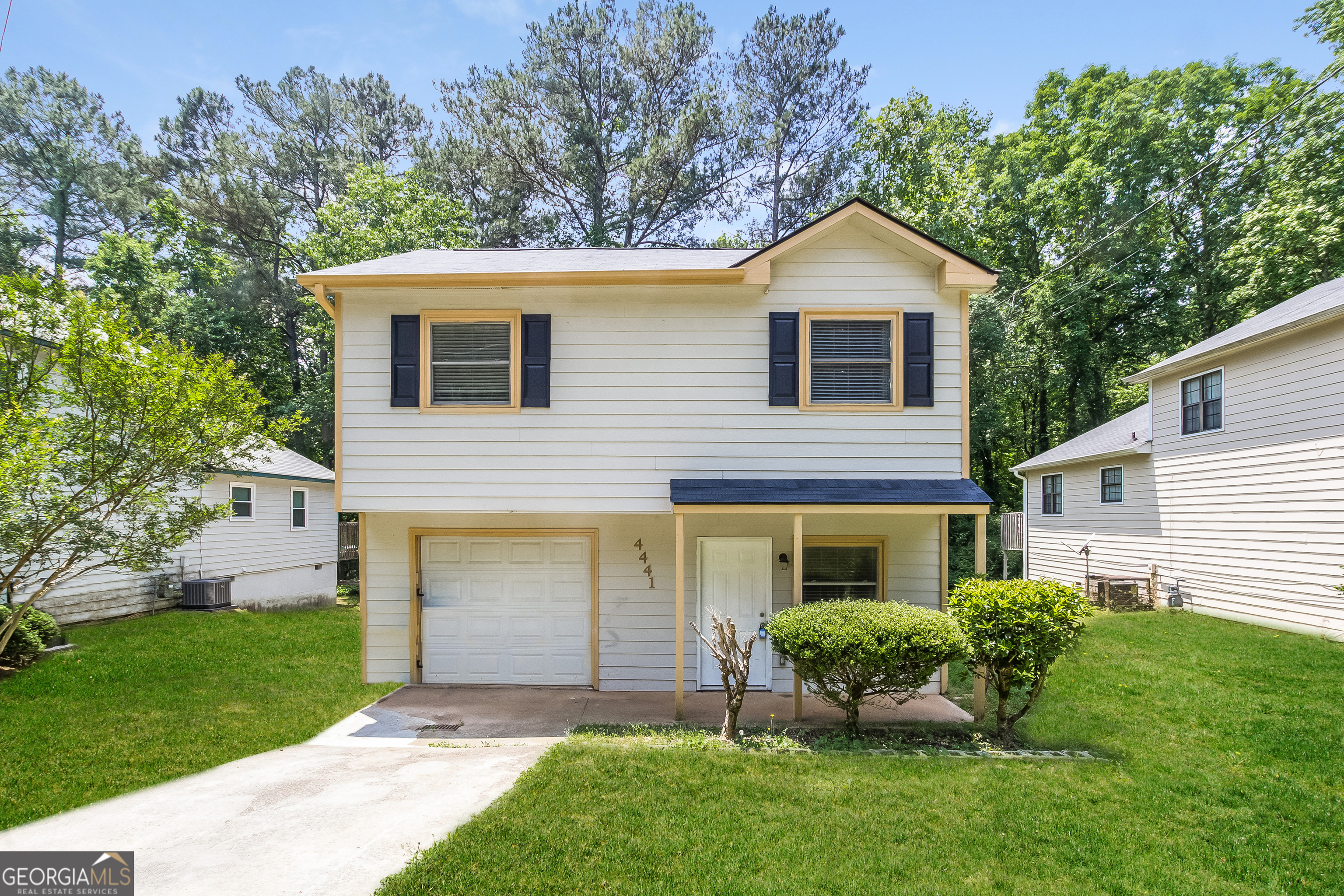 a front view of a house with a yard and trees