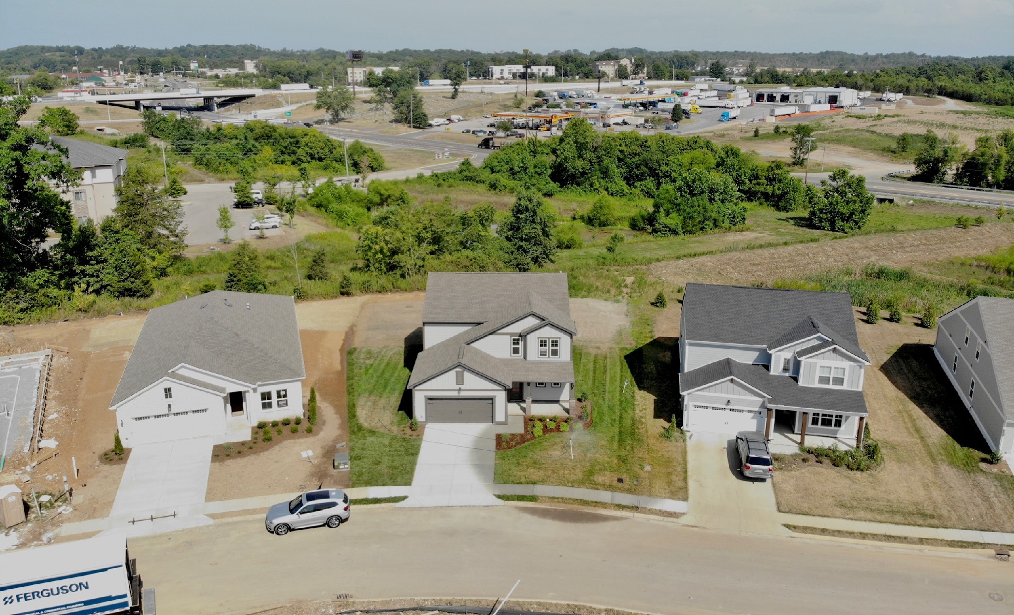 an aerial view of residential houses with outdoor space and parking