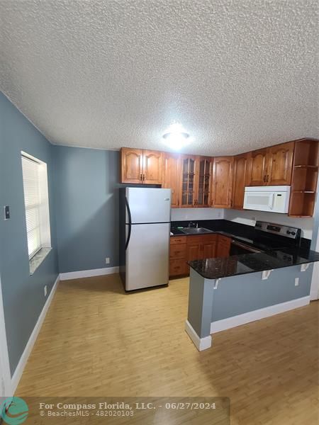 a kitchen with stainless steel appliances granite countertop a stove a sink and a microwave