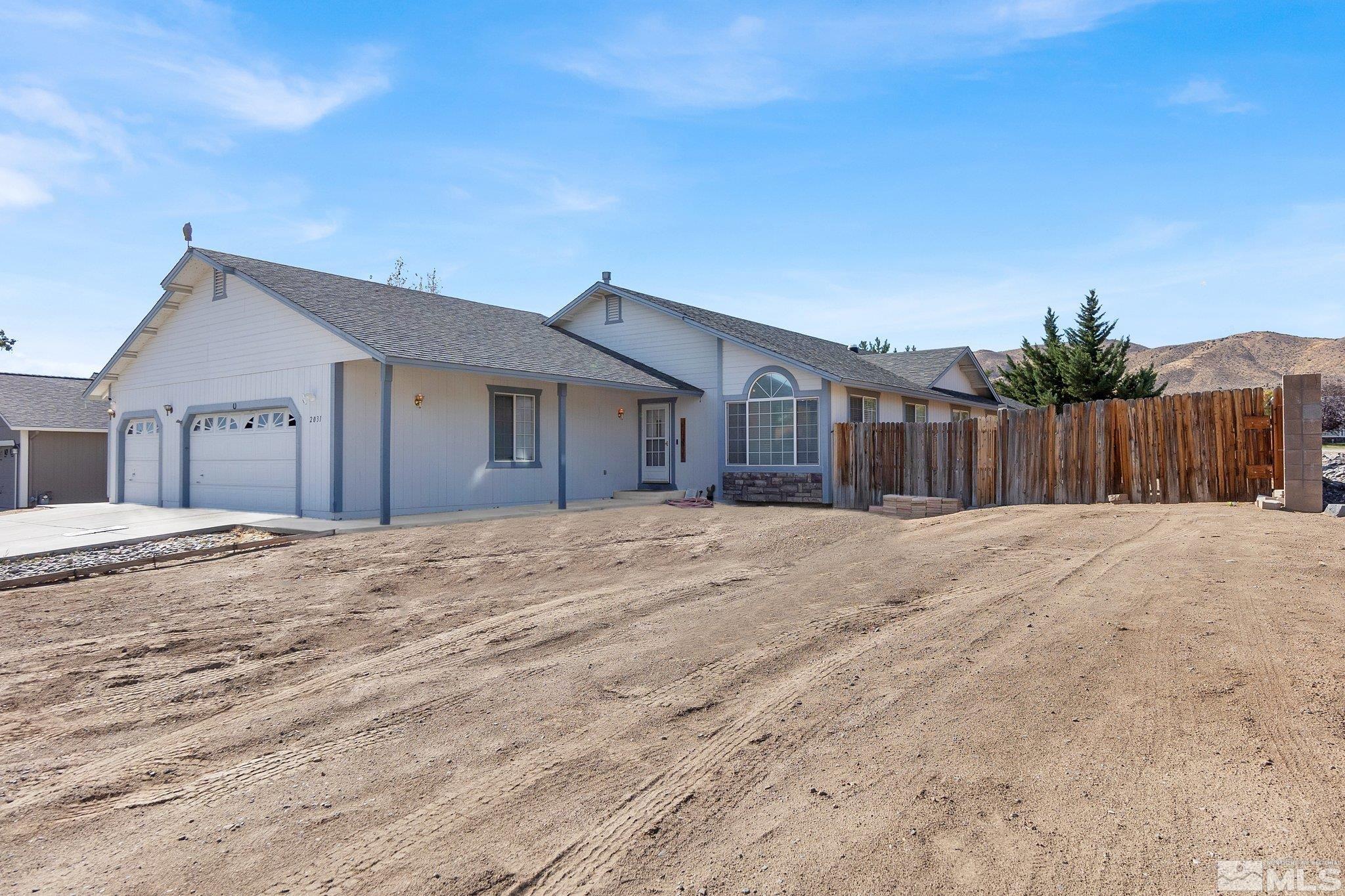 a view of a house with backyard and wooden fence