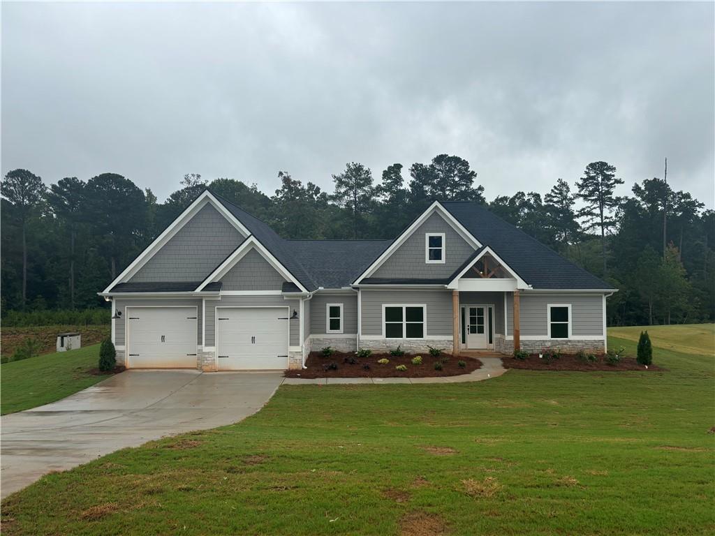 a front view of a house with a garden and lake view