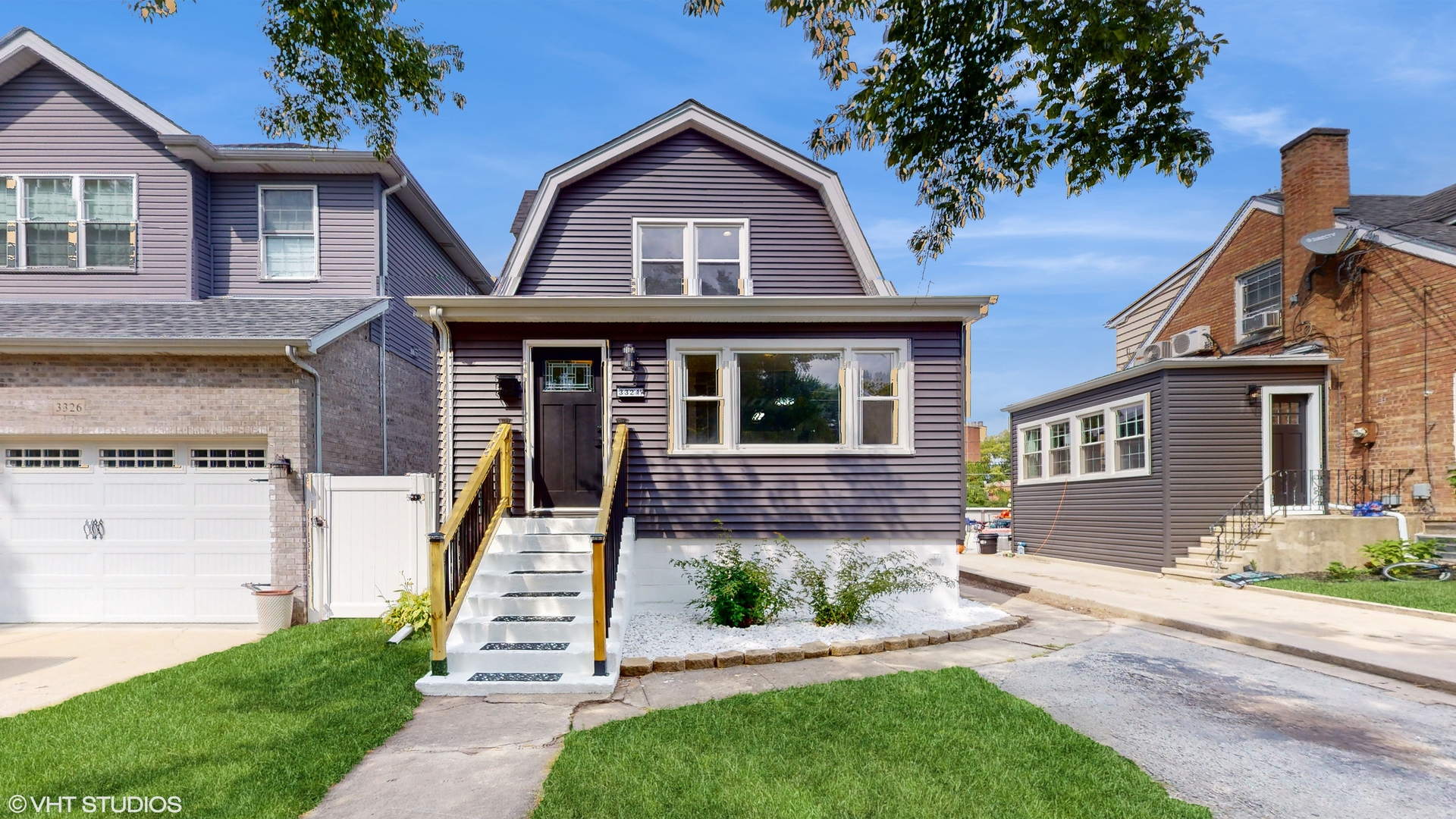 a front view of a house with a yard and potted plants