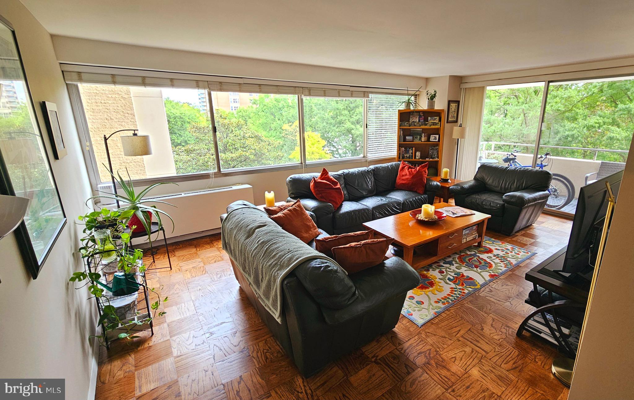 a living room with patio furniture and a potted plant