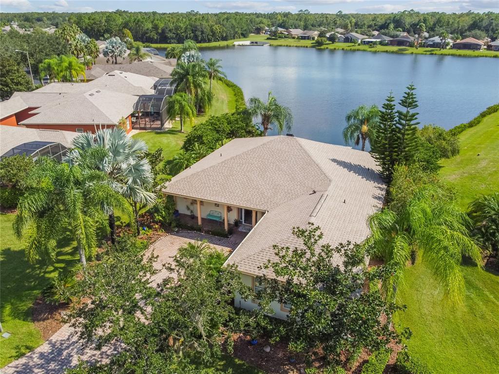 an aerial view of a house with a yard and lake view