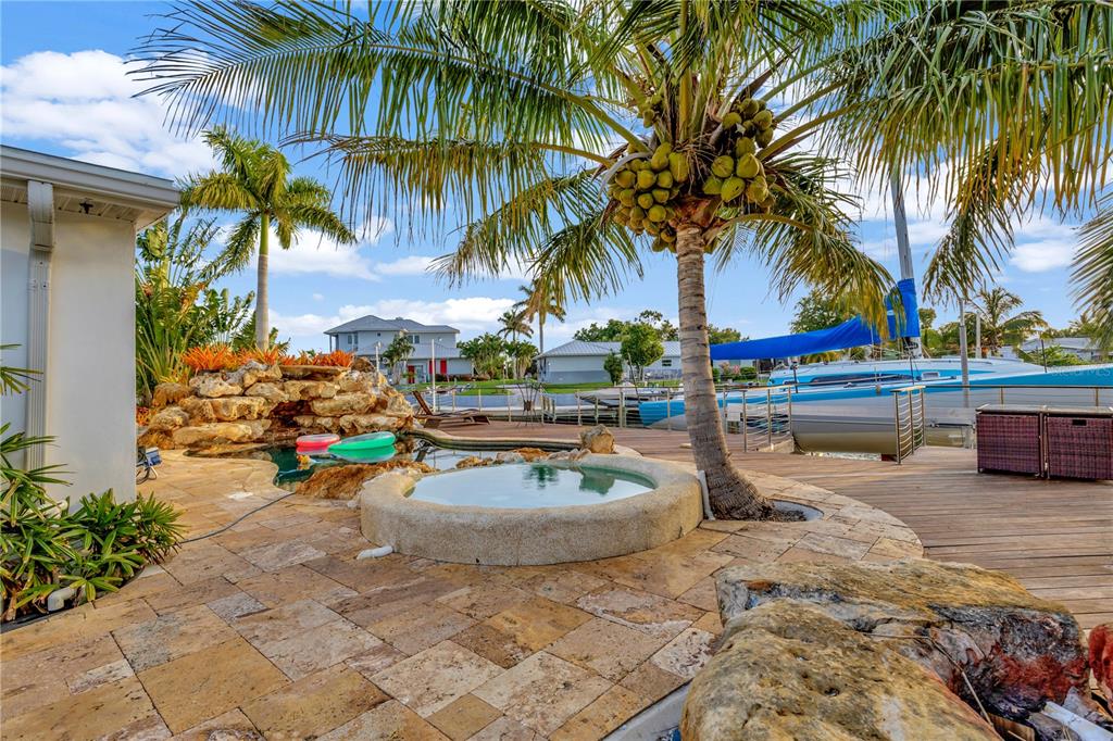 a view of a swimming pool with a lawn chairs under palm trees